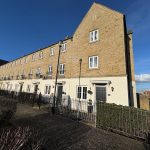 Modern terraced houses under clear blue sky.