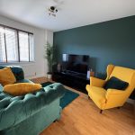 Stylish lounge with green sofa and yellow chair.