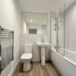 Modern bathroom with tub and white tiles