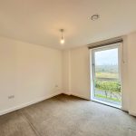 Empty room with carpet and large window view.