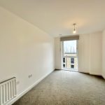 Bright empty room with window and radiator.