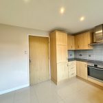 Modern kitchen with wooden cabinets and appliances.