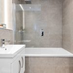 Modern bathroom with sink and tiled walls.