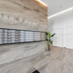 Modern office lobby with mailboxes and plants.