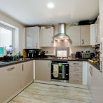 Modern kitchen with appliances and white cabinets.