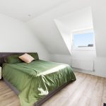 Bright loft bedroom with green bedspread