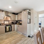 Modern kitchen with appliances and beige cabinets.
