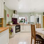 Modern kitchen with dining area and decorative tablecloth.