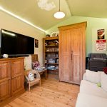 Cosy room with TV, wooden furniture, and decor.