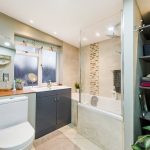 Modern bathroom with bathtub, sink, and plants.