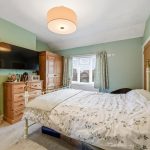 Cosy bedroom with wooden furniture and floral bedding.
