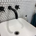 Modern bathroom sink with hexagonal tiles.
