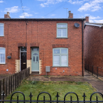 Red brick semi-detached houses with blue sky.