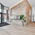 Modern building entrance with mailboxes and plant.