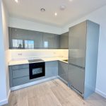 Modern kitchen with grey cabinets and appliances.