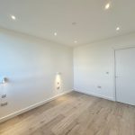 Minimalist empty room with wooden floor and door.