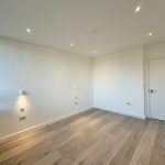 Empty room with wooden floor and white walls.