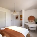 Modern bedroom with cosy decor and desk area.