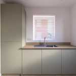 Modern kitchen with minimalist design and natural lighting.