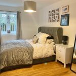 Cosy bedroom with grey bed and decor.