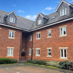 Residential building with brick facade and dormer windows.