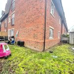 Backyard with grass, shed, and toy car