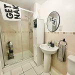 Modern bathroom with shower, sink, and toilet.