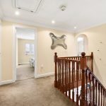 Bright hallway with wooden bannister and modern decor.