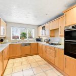 Modern kitchen with wooden cabinets and appliances.