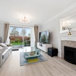 Modern living room with garden view and fireplace.