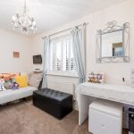 Cosy room with sofa, mirror, table and decor.