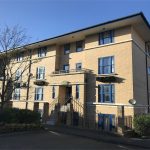 Three-storey brick building with blue window frames.