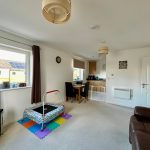 Modern living room with kitchen, trampoline, and decor
