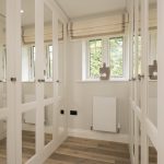 Modern dressing room with mirrored wardrobes and window.