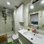 Modern bathroom with shower and vanity unit.