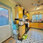Modern kitchen with wooden cabinets and geometric tiles.