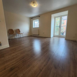 Empty room with wooden floor and two chairs.