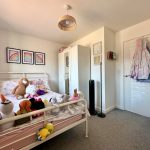 Child's bedroom with toys and rainbow art.