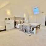 Modern bedroom with skylight and white furniture