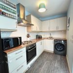 Modern kitchen with appliances and wooden countertops.