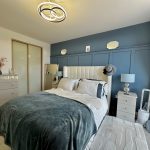 Modern bedroom with grey and blue decor.