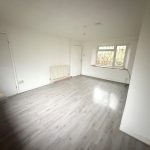 Empty white room with wooden floor and window.