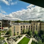 Modern buildings and scenic courtyard view under cloudy sky.