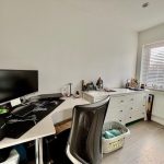 Modern home office with desk and computer setup.