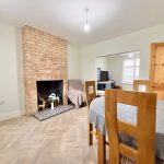 Cosy dining room with brick fireplace and table.
