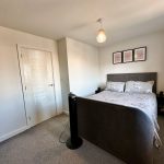 Cosy bedroom with double bed and framed artwork.