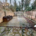 Outdoor patio with seating and surrounding fence.