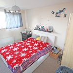 Cosy bedroom with red snowflake blanket.
