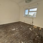 Empty room with wooden floors and white walls.