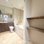 Modern bathroom with sink, toilet, and bathtub.